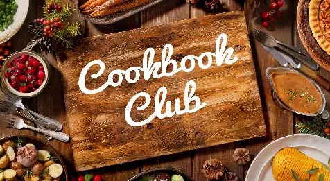 Wooden cutting board surrounded by ingredients with text Cookbook Club