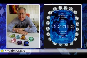 Author Jeffrey Edward Post seated behind a collection of large gemstones along side an image of his book The Smithsonian National Gem Collection Unearthed