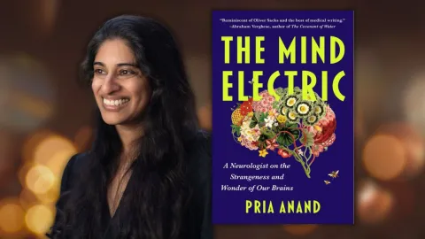 The author next to her book which shows a depiction of the brain made of images of flowers.